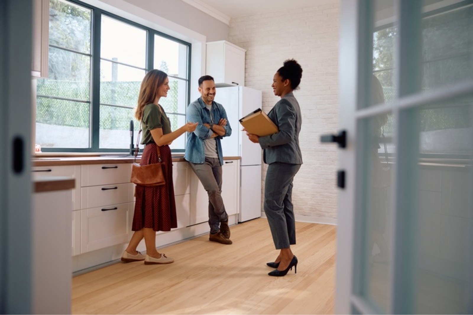 CENTURY 21 Together agent consulting with homebuyers in a bright kitchen